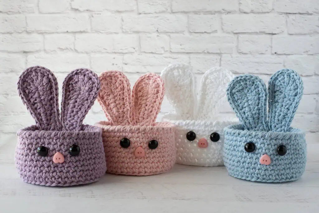 bunny baskets out of purple, pink, white and blue yarn