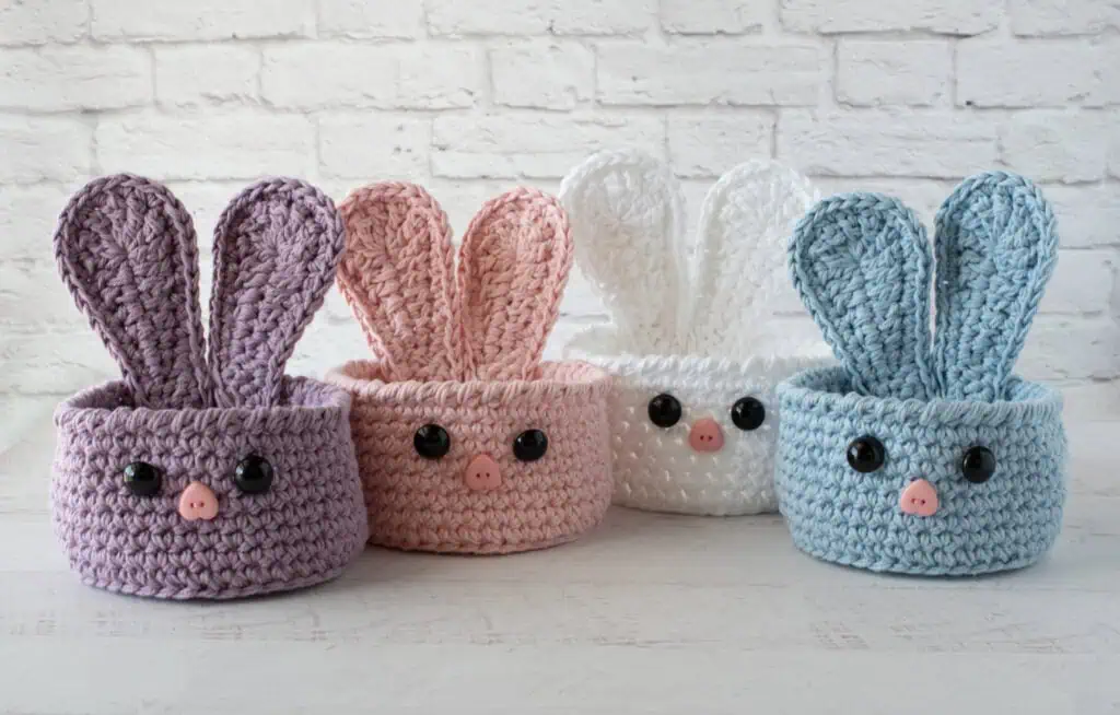 bunny baskets out of purple, pink, white and blue yarn