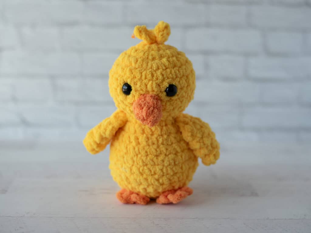 Crochet yellow chick plush toy with black eyes and orange beak