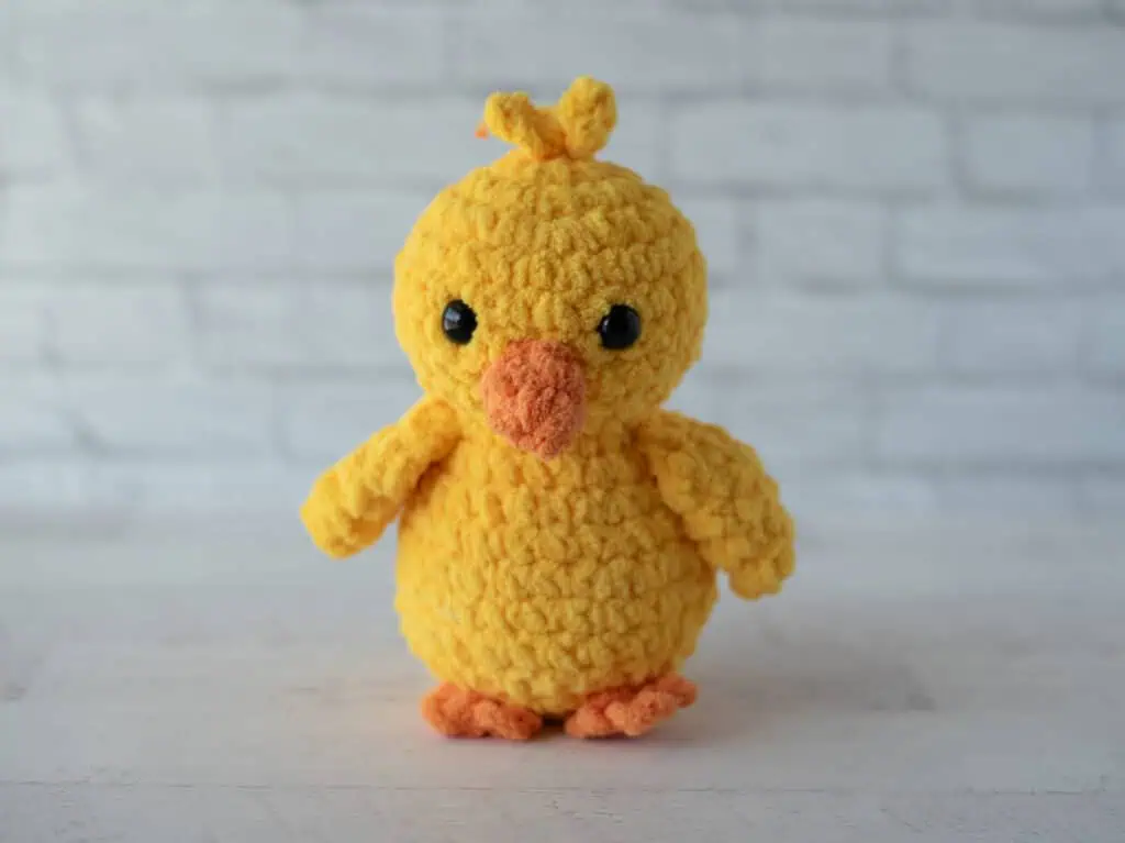 Crochet yellow chick plush toy with black eyes and orange beak