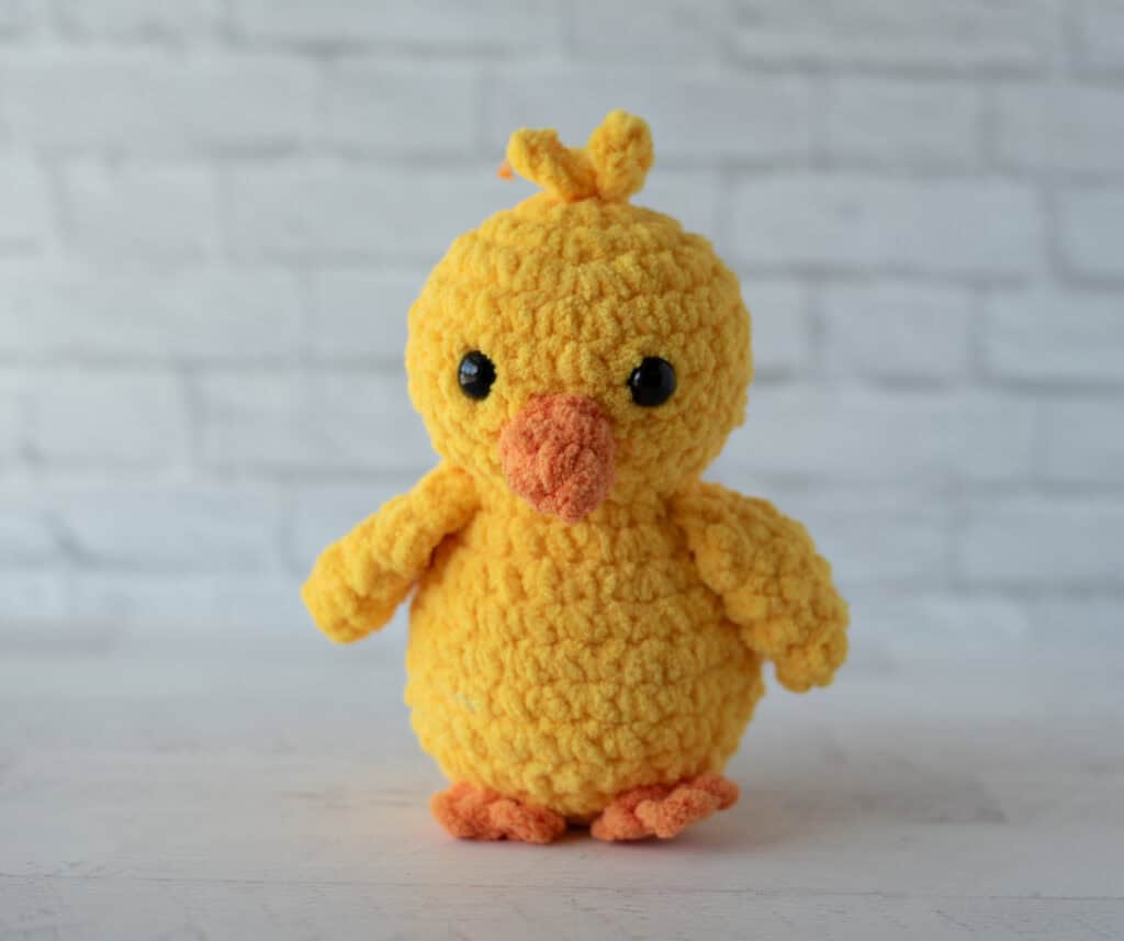 Crochet yellow chick plush toy with black eyes and orange beak