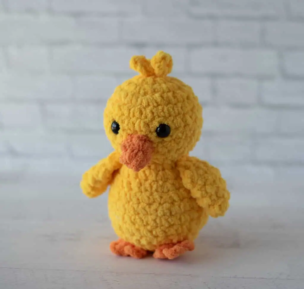 Crochet yellow chick plush toy with black eyes and orange beak