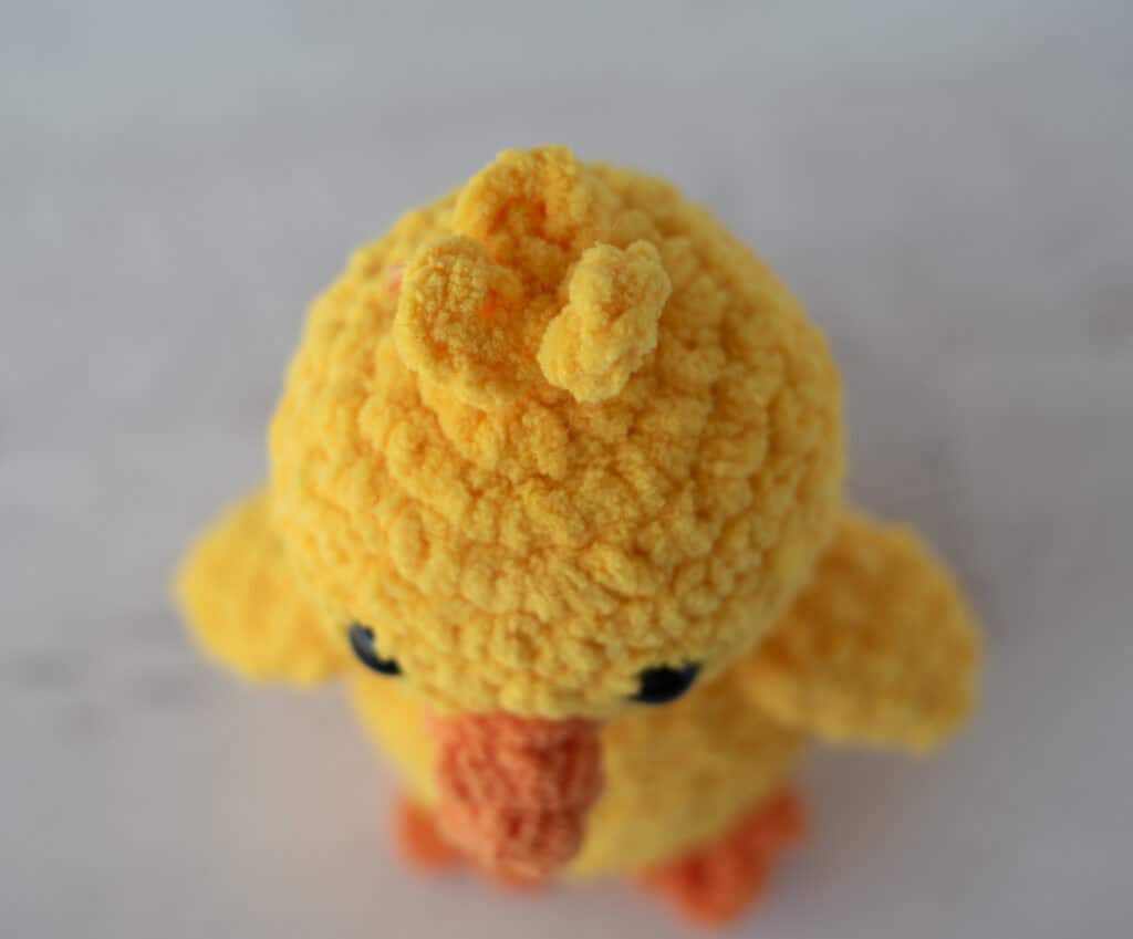 Crochet yellow chick plush toy with black eyes and orange beak