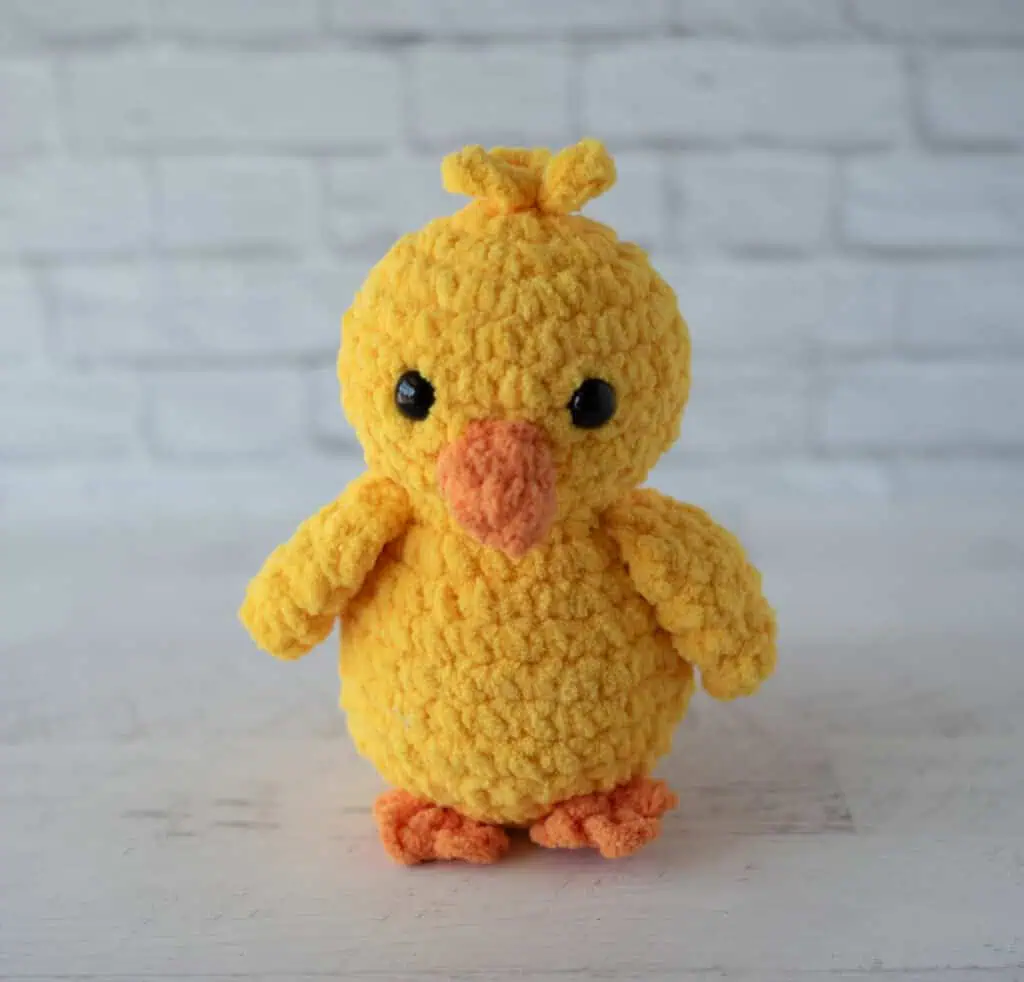 Crochet yellow chick plush toy with black eyes and orange beak