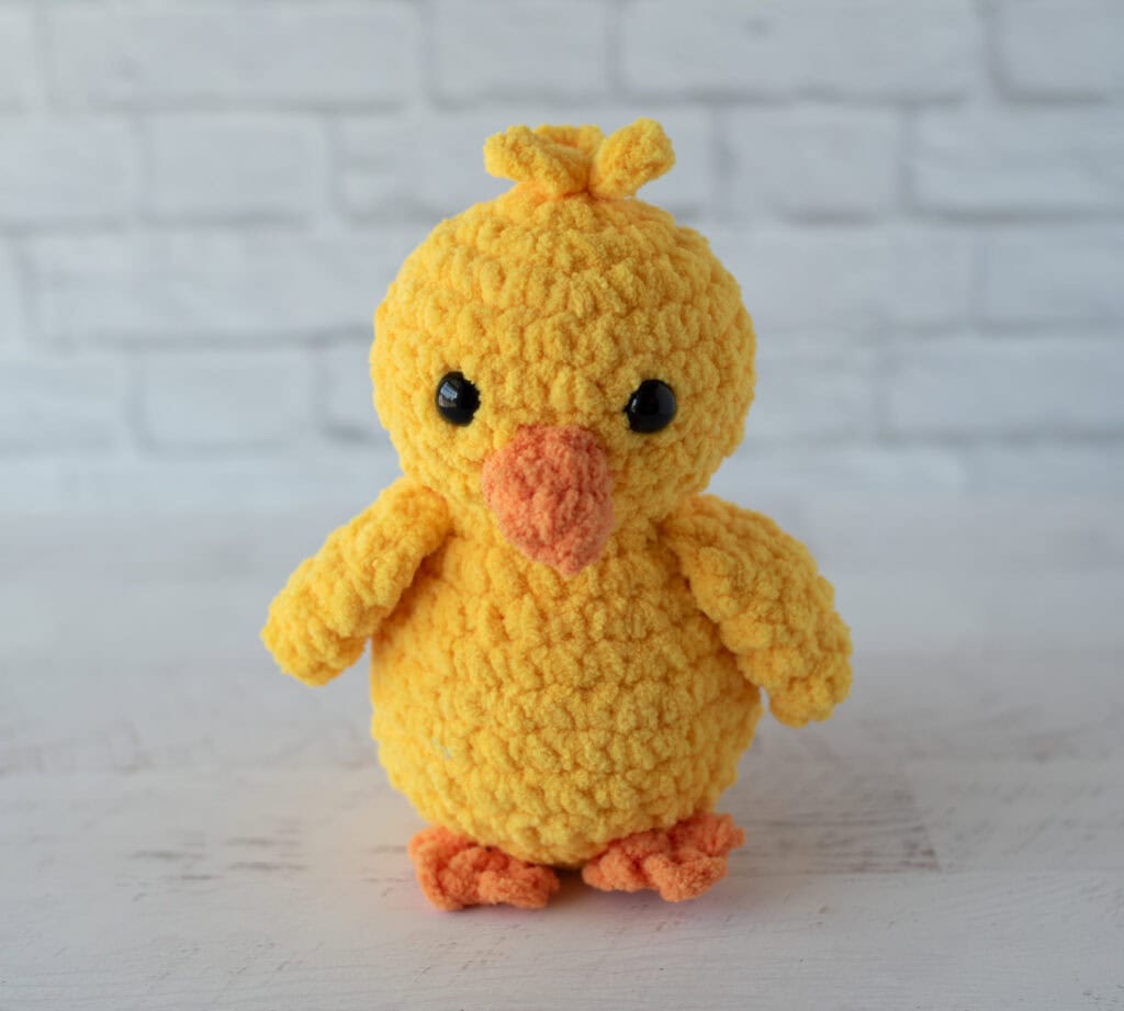 Crochet yellow chick plush toy with black eyes and orange beak