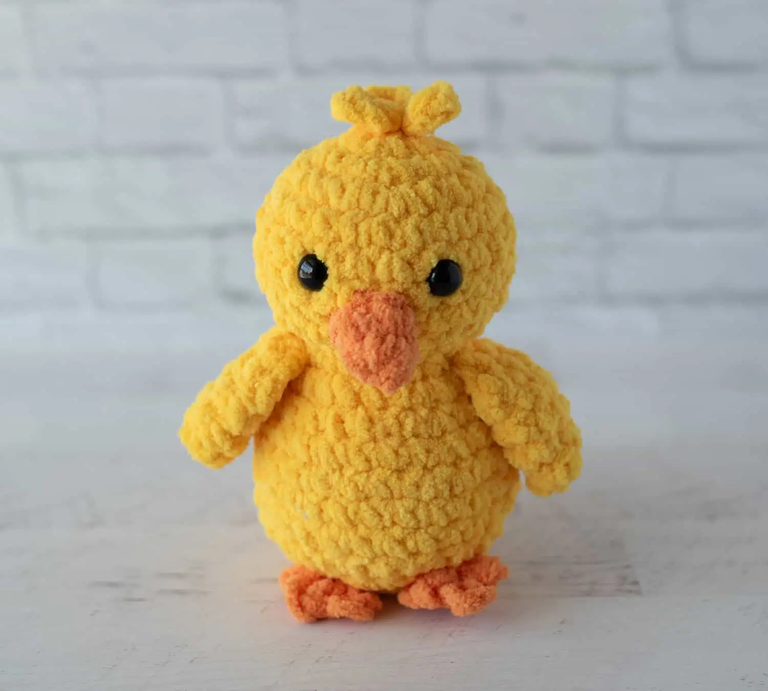 Crochet yellow chick plush toy with black eyes and orange beak