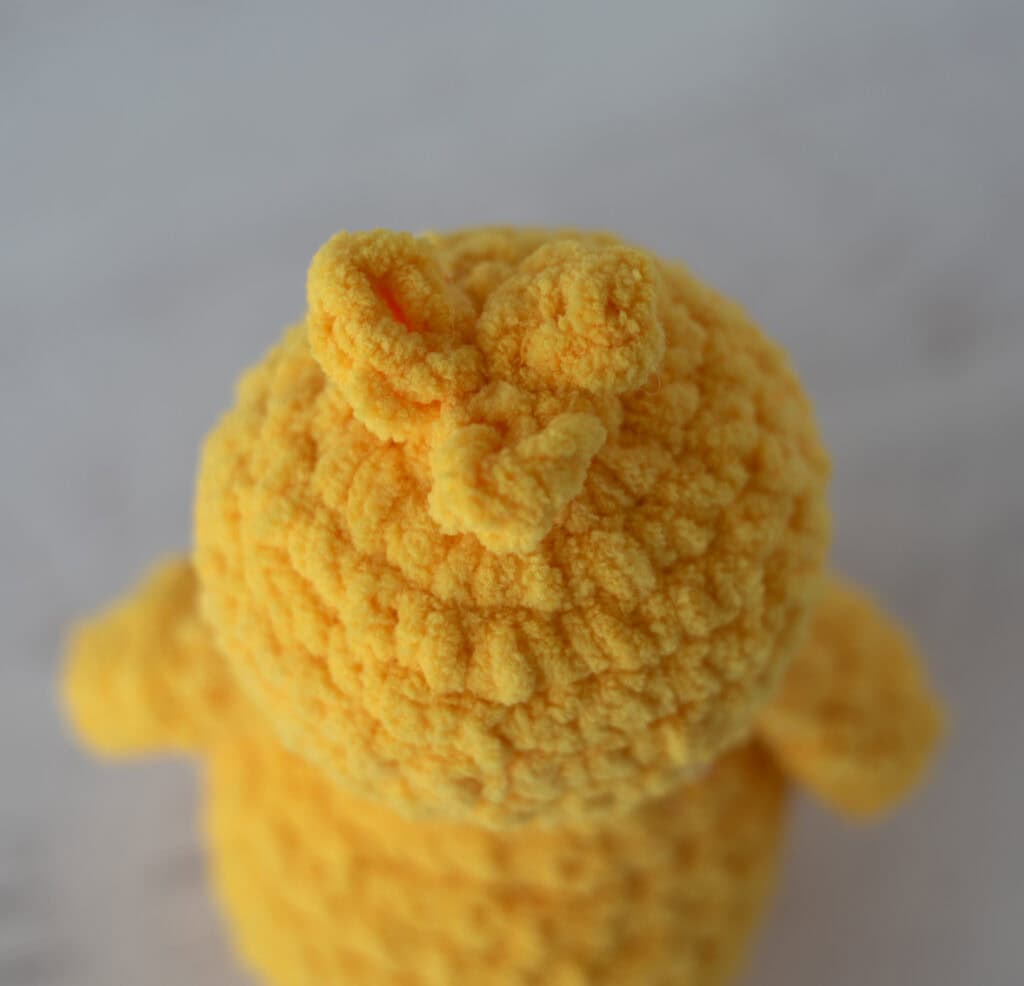 Top of crochet chick's head in yellow yarn