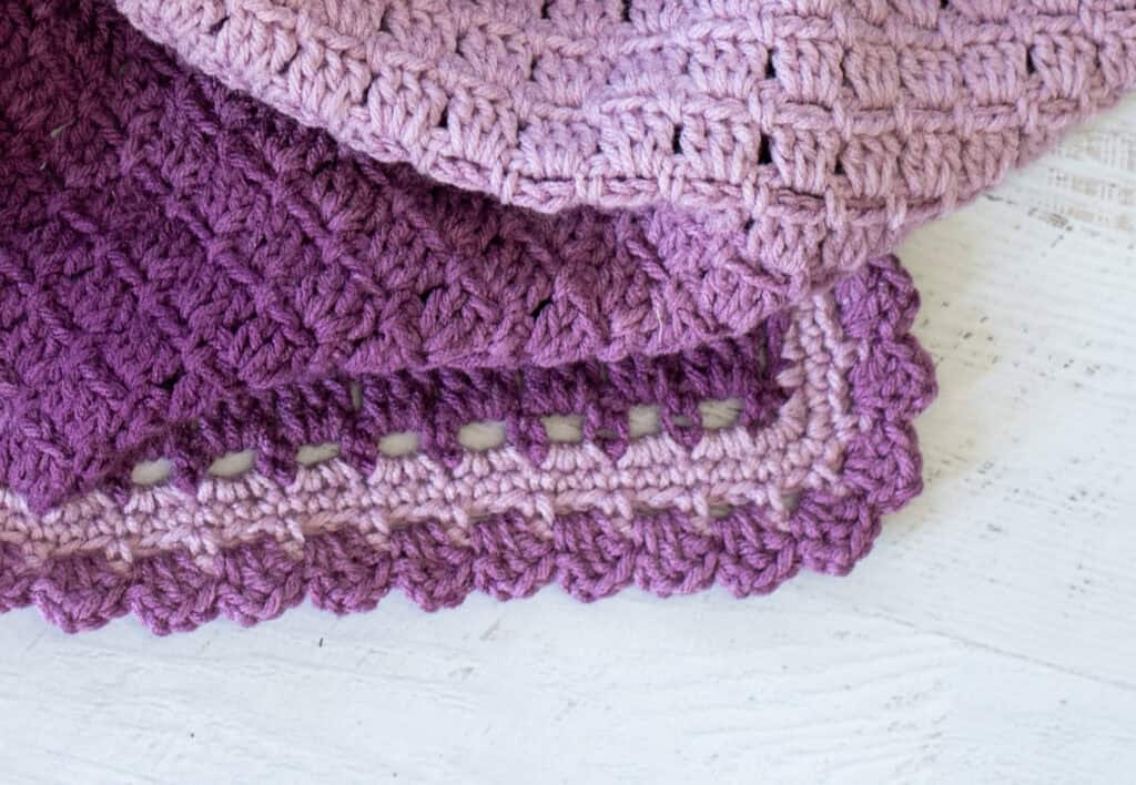 Corner of crochet baby afghan in purple variegated yarn