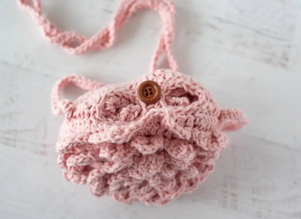Button closure on pink crochet market bag