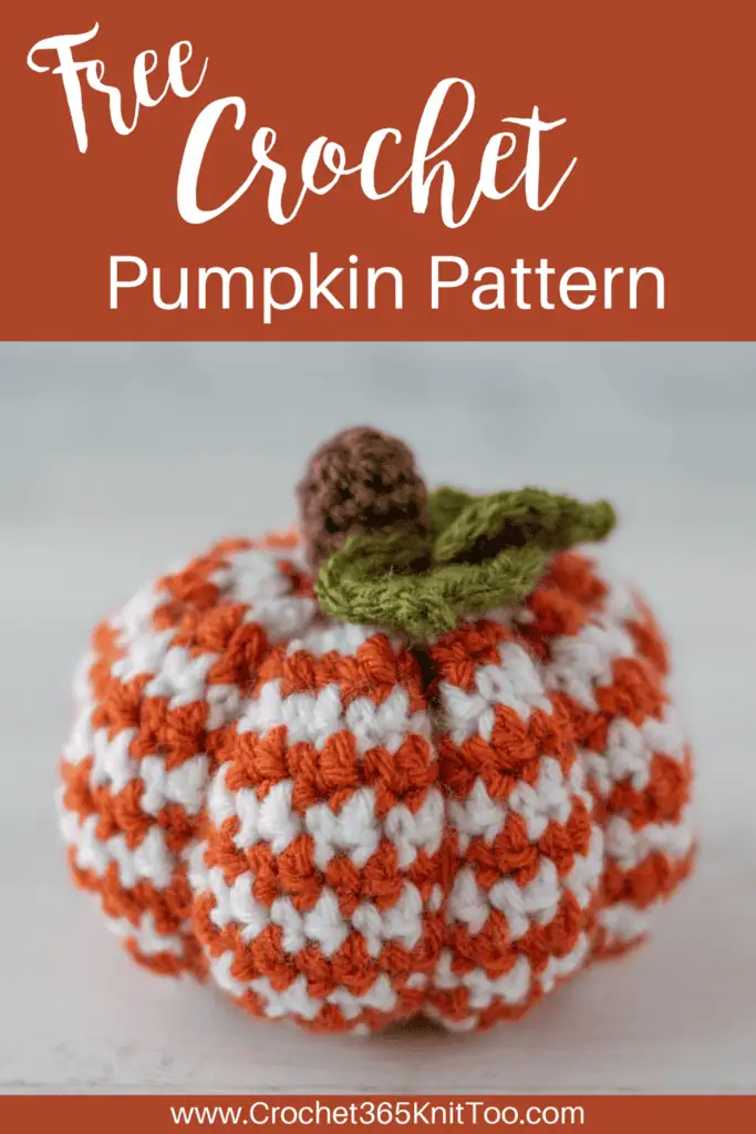 Image of crochet houndstooth patterned pumpkin in orange and white yarn with brown stem and green leaves