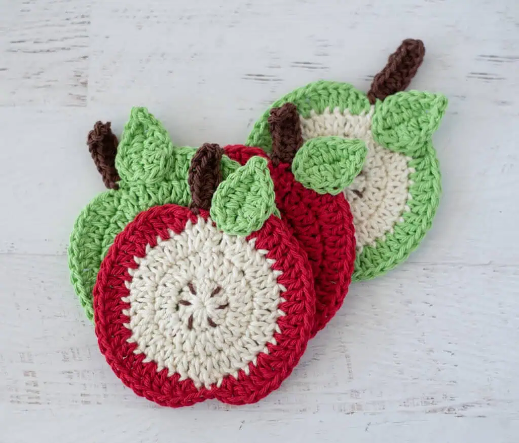 Crochet apple coasters in red, green and cream yarn