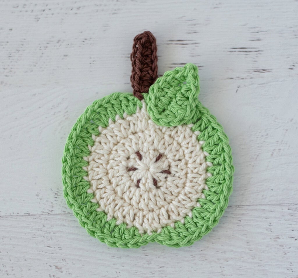 Green apple slice coaster with brown seeds