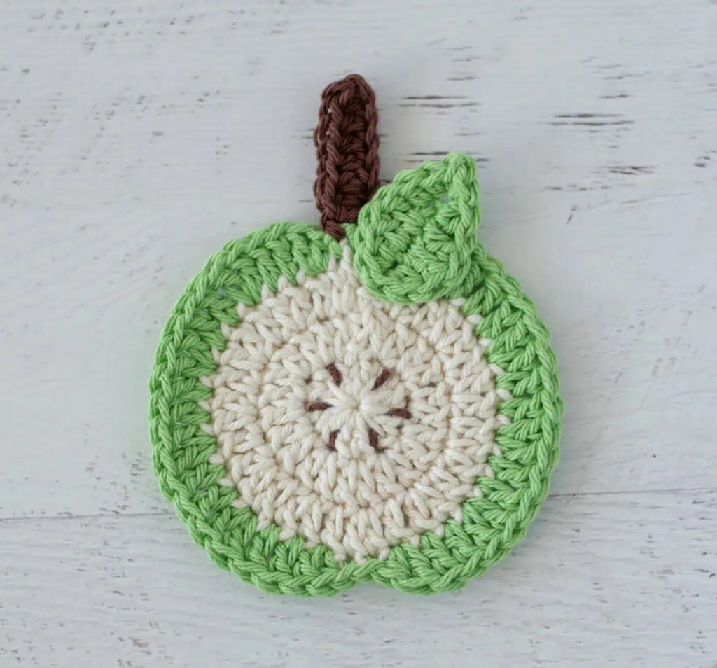 Green apple slice coaster with brown seeds