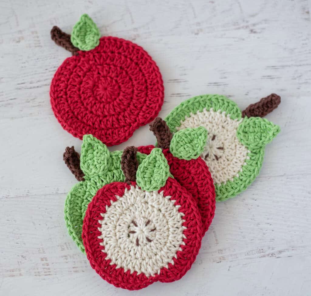 Crochet apple coasters in red, green and cream yarn